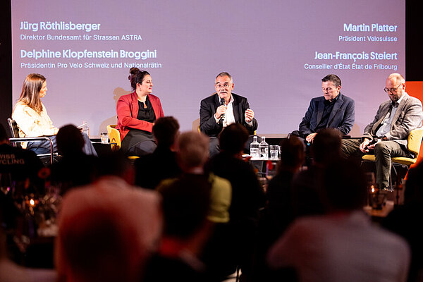 Männer und Frauen auf einer Bühne.