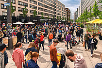 Cycle Week 2024. Viele Menschen laufen durch eine Strasse mit Verkaufsständen.