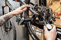 Einstiegskurs für Velowerkstatt-Mitarbeitende. Neue Daten verfügbar. Eine Person misst die Dicke einer Bremsscheibe am Fahrrad.